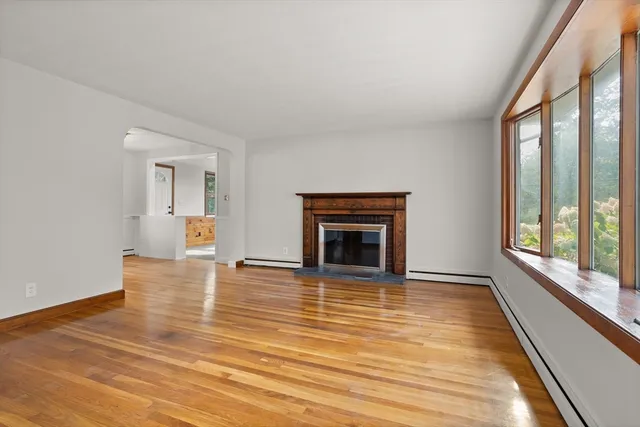 a view of empty room with wooden floor and fireplace