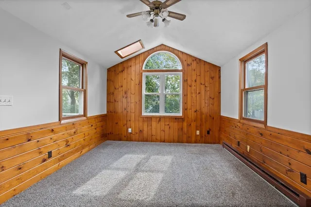 wooden floor with chandelier next to a window