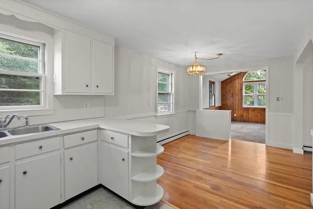 a view of a kitchen with wooden floor and a window