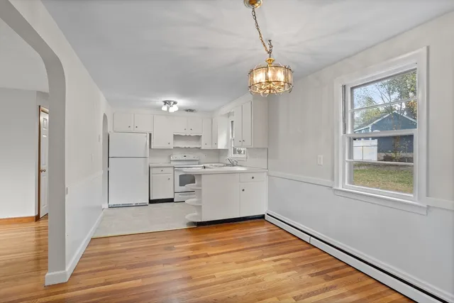 a view of a kitchen with wooden floor and a window