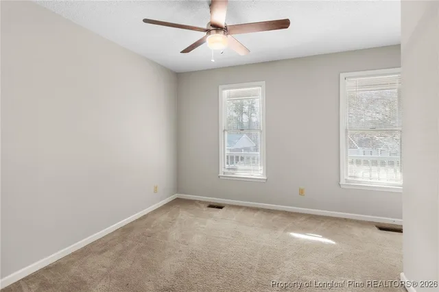 an empty room with a window and a fan