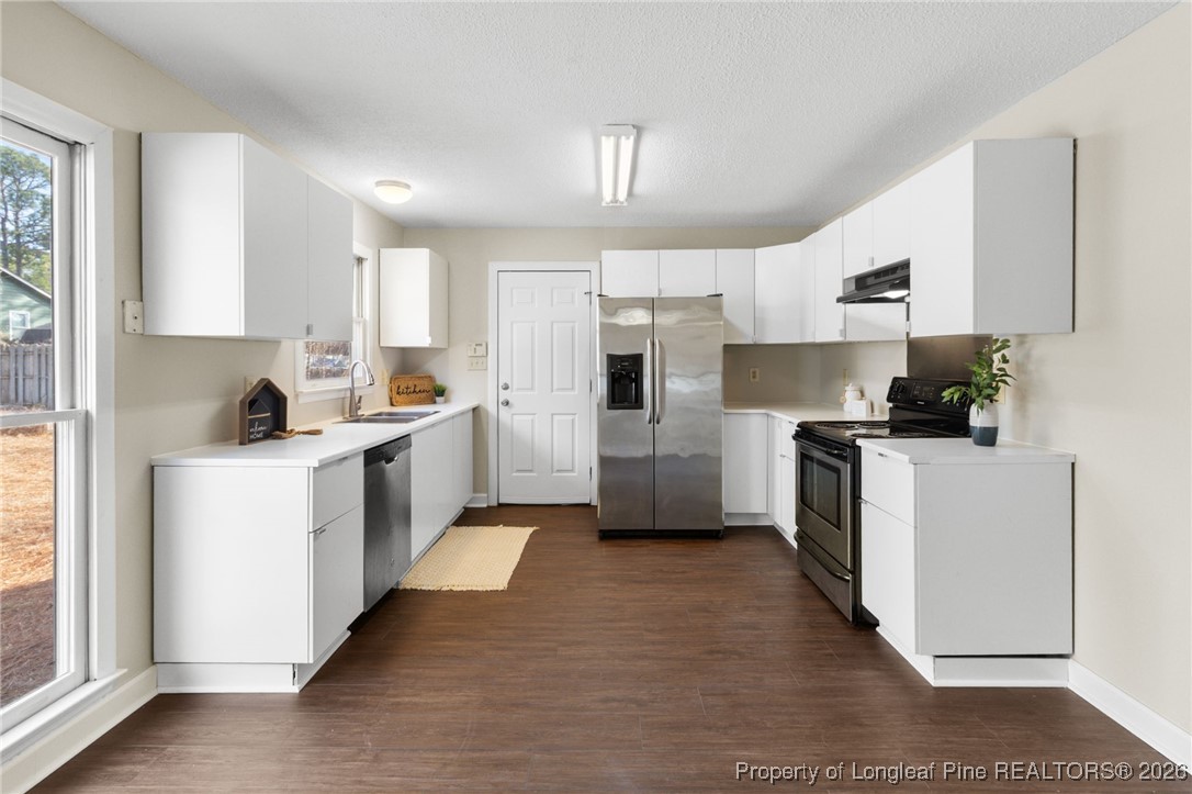3340 Hunting Bay Drive Spring Lake, NC 28390 - Photo 9 of 28 a kitchen with cabinets a sink and white stainless steel appliances