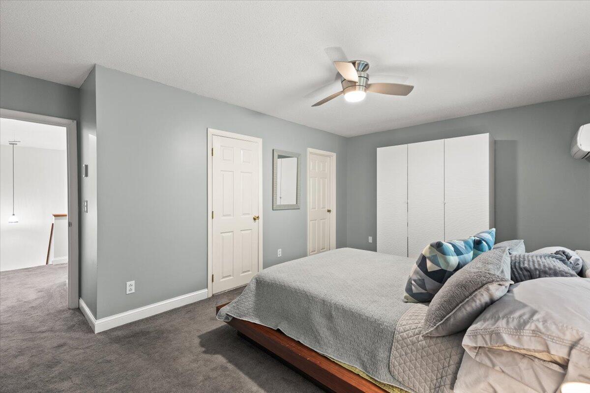 84 Round House Road Bourne, MA 02532 - Photo 28 of 35 a spacious bedroom with a bed and a chandelier