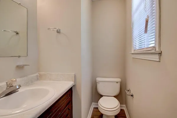 a bathroom with a granite countertop toilet a sink and a mirror