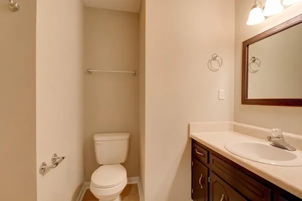 a bathroom with a toilet a sink and mirror