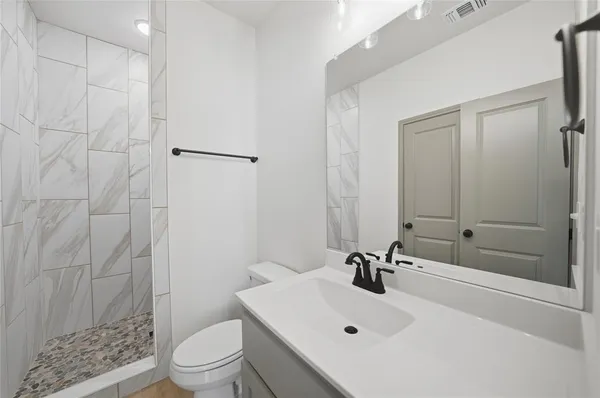 a bathroom with a sink a toilet and shower