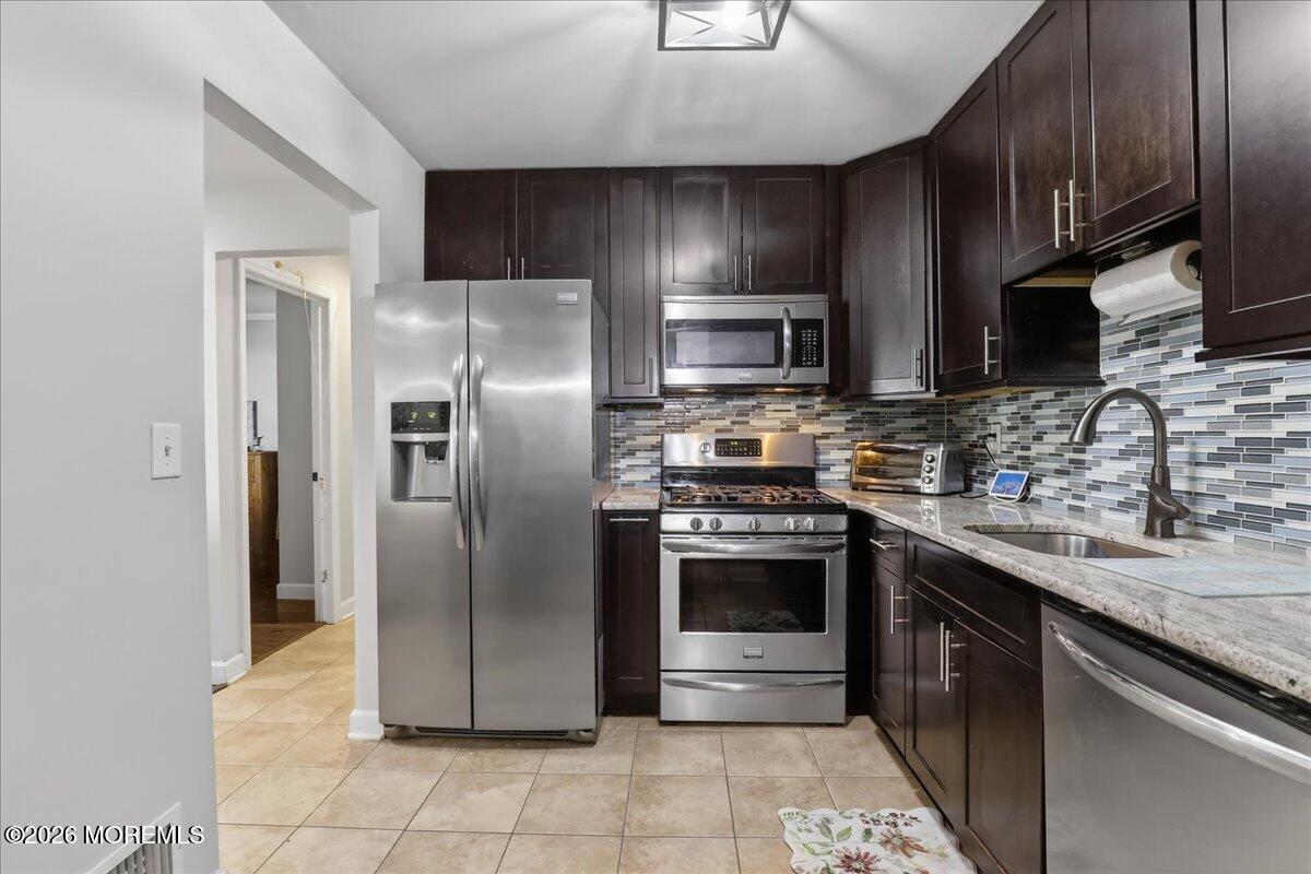 402 Daisy Court Jackson, NJ 08527 - Photo 17 of 44 a modern kitchen with stainless steel appliances granite countertop a stove a refrigerator and a sink