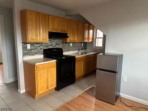 a kitchen with stainless steel appliances granite countertop wooden cabinets stove top oven and sink