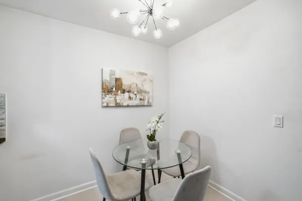 a dining room with furniture and a chandelier fan