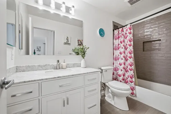 a bathroom with a granite countertop sink mirror vanity and toilet