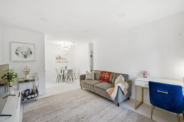 a living room with furniture and a potted plant on a dresser