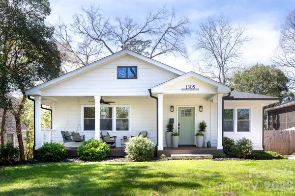 a front view of a house with a yard and plants