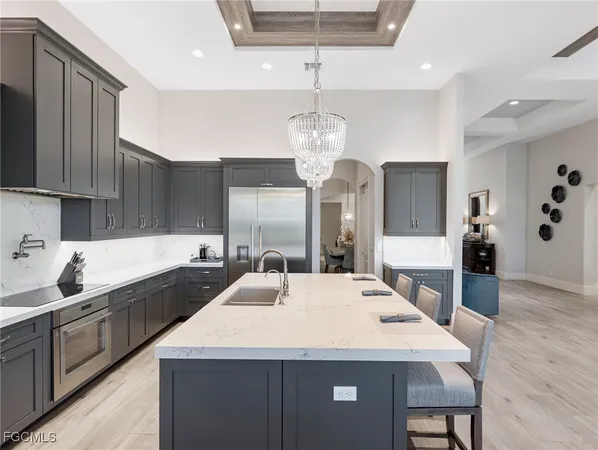 a large kitchen with sink a refrigerator and chairs