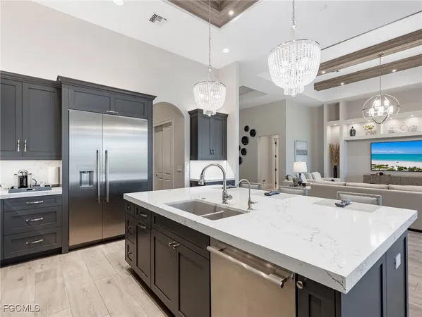 a kitchen with kitchen island granite countertop a sink and refrigerator