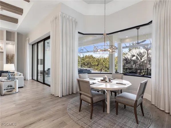 a dining room with furniture a chandelier and wooden floor