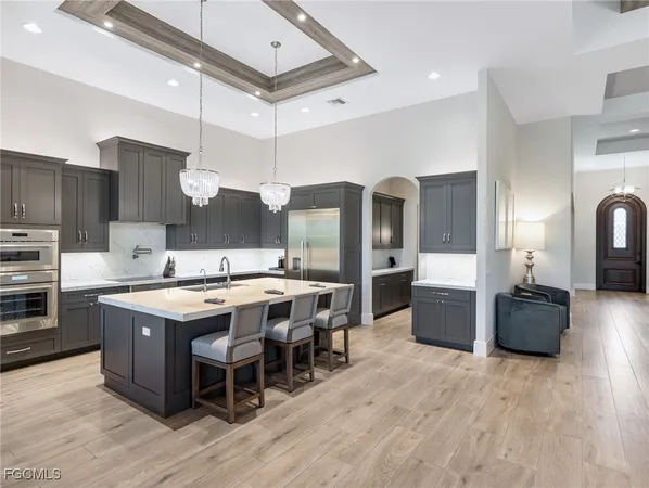 a kitchen with stainless steel appliances a stove a sink dishwasher and a refrigerator with wooden floor