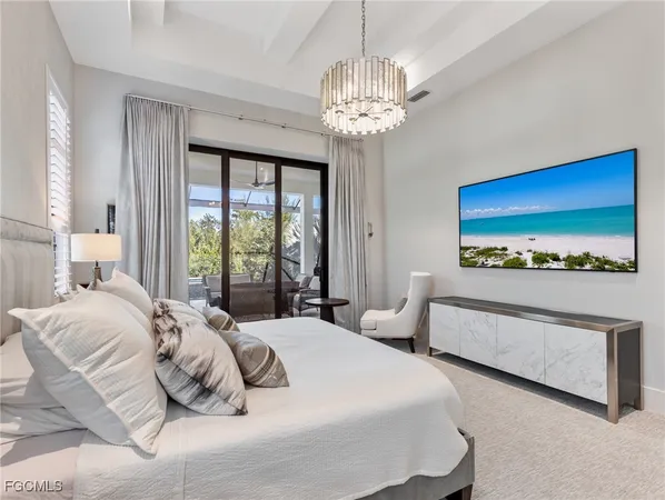 a bedroom with a large bed and a chandelier