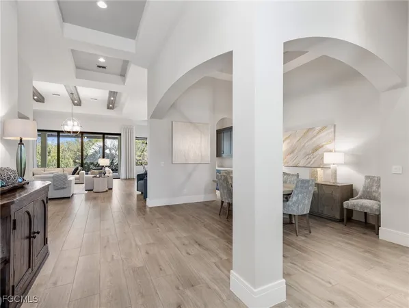 a view of a living room and kitchen with furniture wooden floor and windows