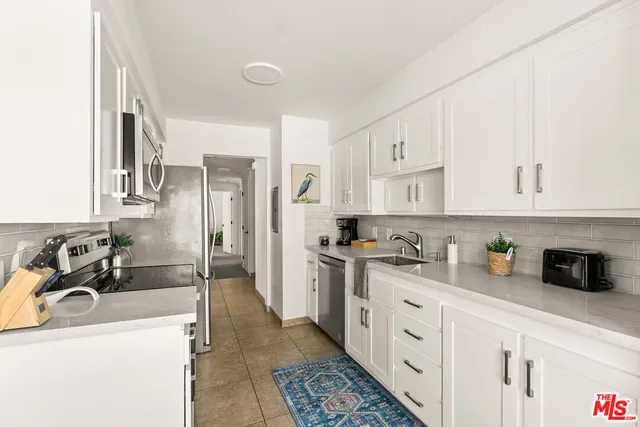 a kitchen with stainless steel appliances a sink stove and refrigerator