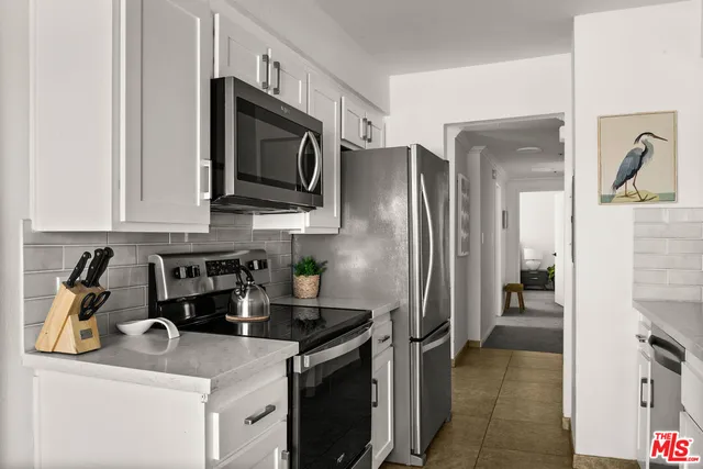 a kitchen with stainless steel appliances granite countertop a refrigerator a stove top oven a sink and dishwasher