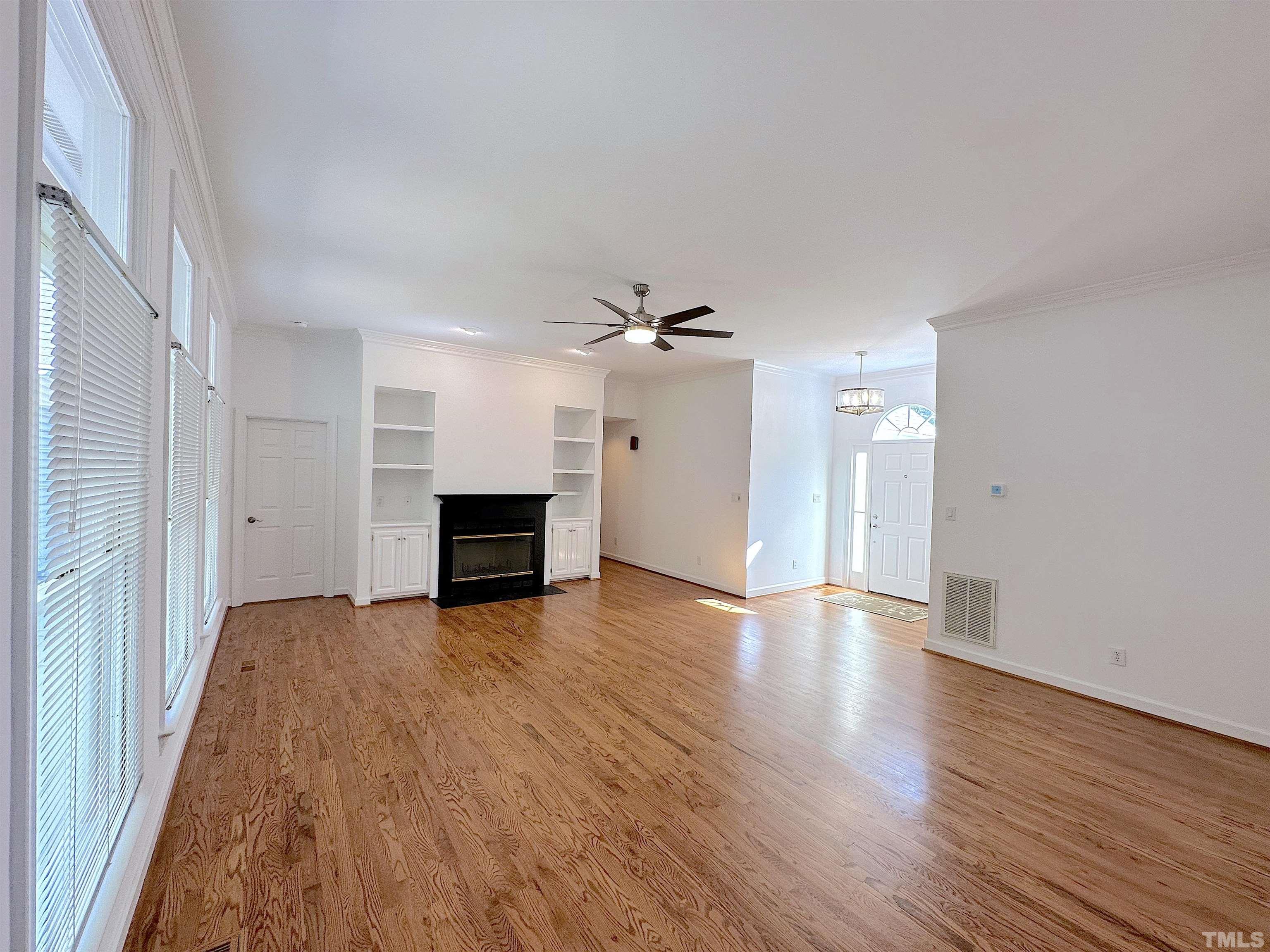 105 Wagon Trail Drive Cary, NC 27513 - Photo 2 of 22 a view of empty room with wooden floor and fireplace