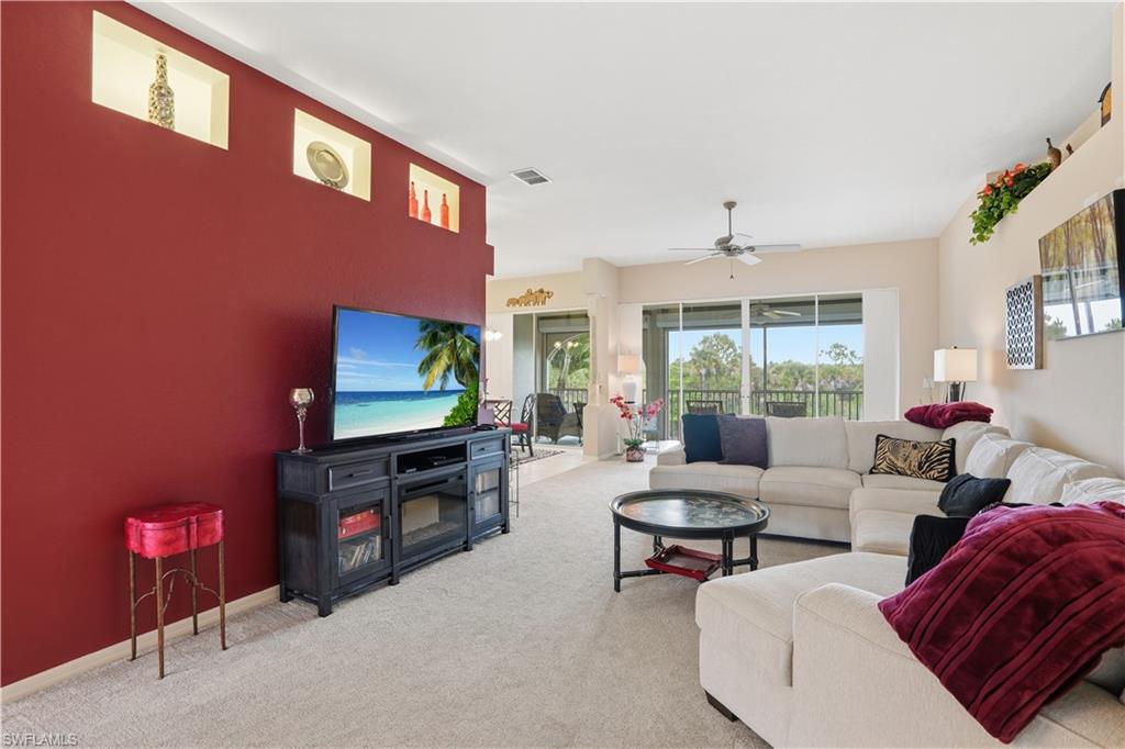 10871 Crooked River Road, Unit 202 Estero, FL 34135 - Photo 4 of 46 a living room with furniture a floor to ceiling window and a flat screen tv