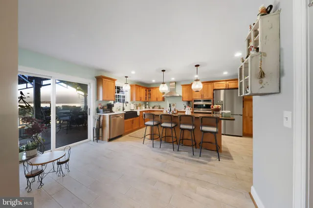 a kitchen with stainless steel appliances granite countertop a refrigerator a sink a stove and island