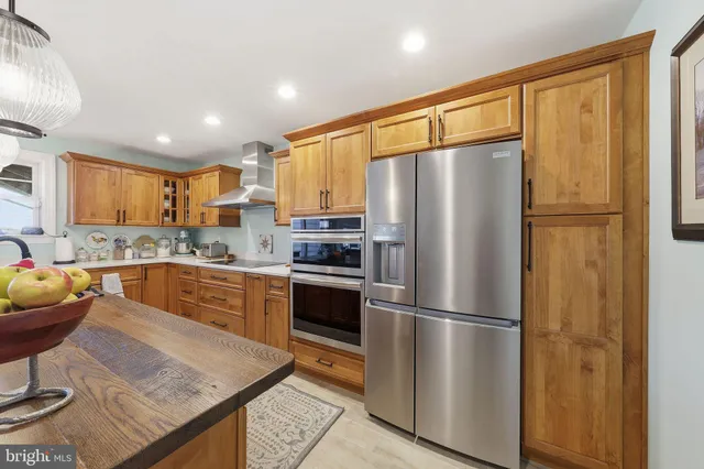 a view of a kitchen with kitchen island and stainless steel appliances