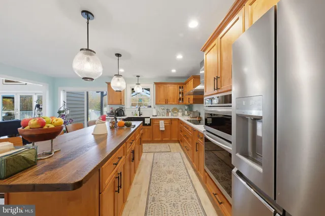 a kitchen with stainless steel appliances granite countertop a stove a sink and a refrigerator