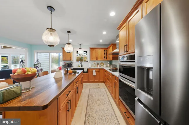 a kitchen with granite countertop a stove a sink a counter space and cabinets