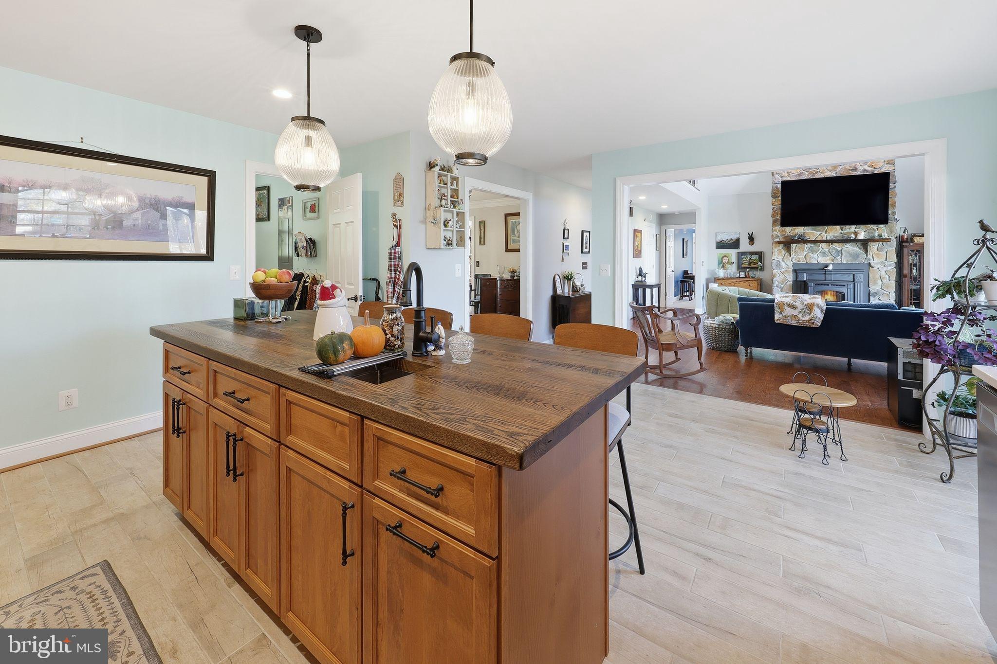 121 Little Eagle Road Centreville, MD 21617 - Photo 27 of 64 a kitchen with granite countertop a stove a sink dishwasher a dining table and chairs with wooden floor