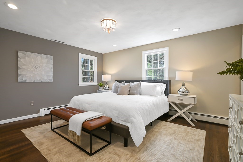 28 Hadley Road Sudbury, MA 01776 - Photo 16 of 30 a bedroom with a bed a table and chair