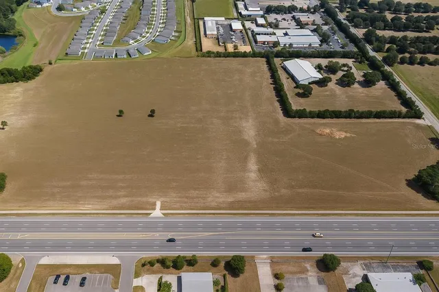 an aerial view of ocean and residential houses with outdoor space