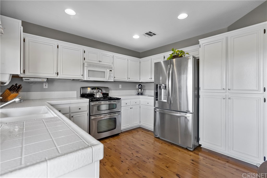 27710 Kristin Lane Saugus, CA 91350 - Photo 16 of 32 a kitchen with cabinets and stainless steel appliances