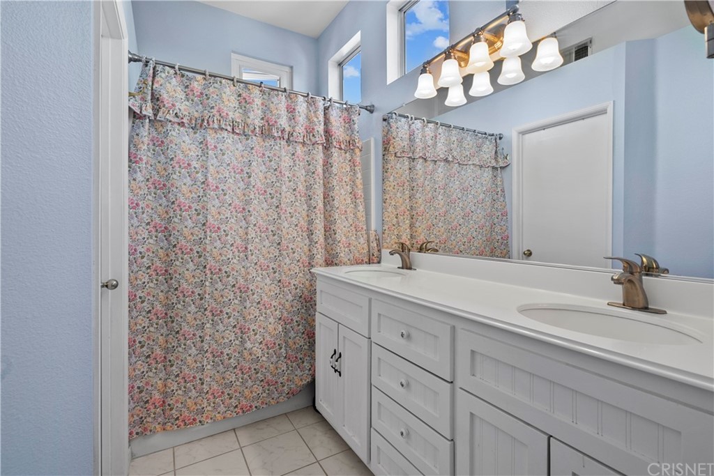 27710 Kristin Lane Saugus, CA 91350 - Photo 28 of 32 a bathroom with a double vanity sink and a mirror