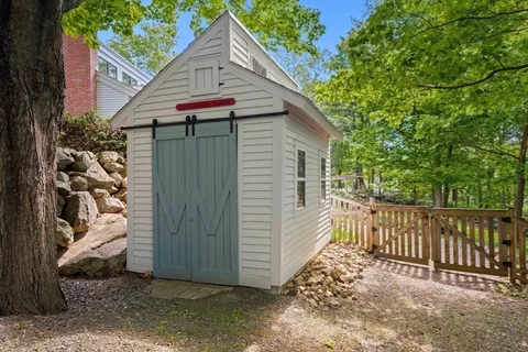 a view of small house with a yard and wooden fence