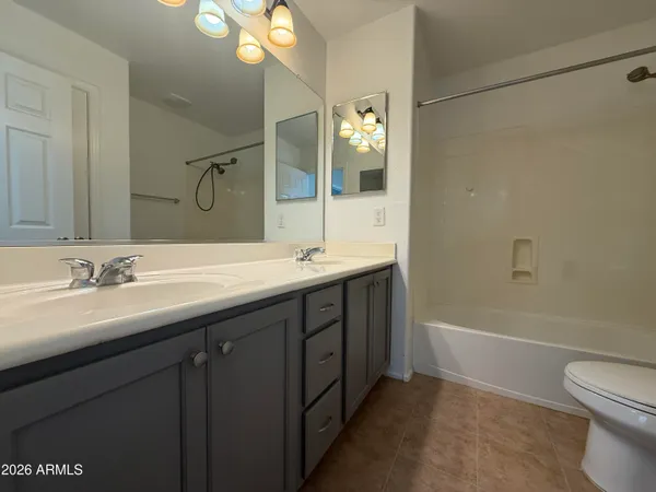 a bathroom with a double vanity sink mirror and toilet
