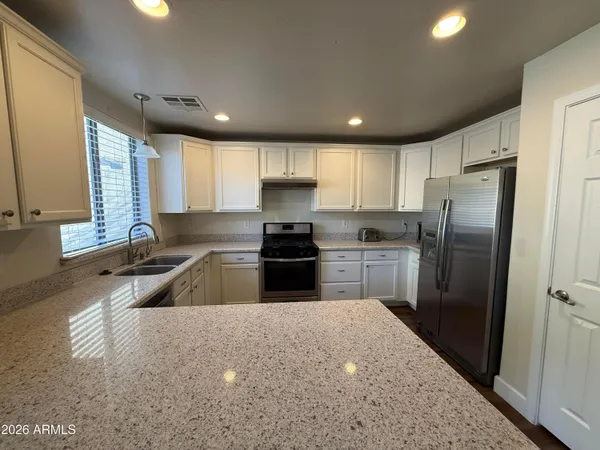 a kitchen with granite countertop a refrigerator and a sink