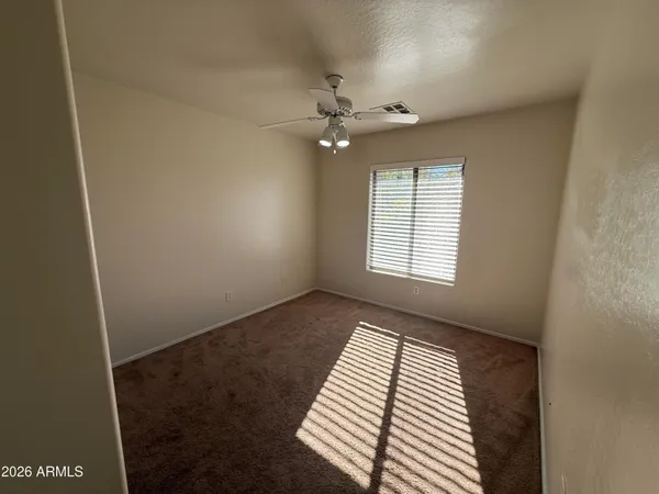 an empty room with windows and fan