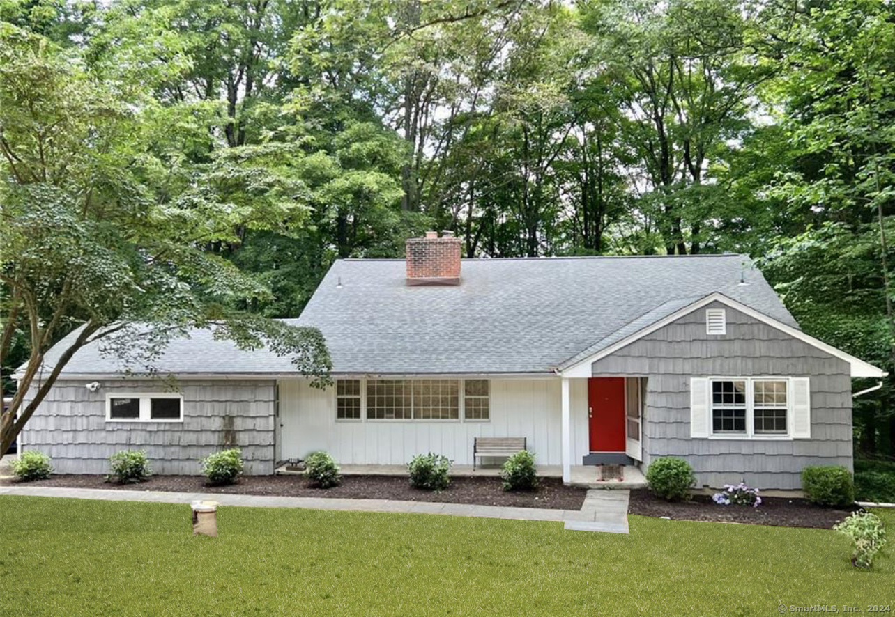 a front view of a house with a yard and trees