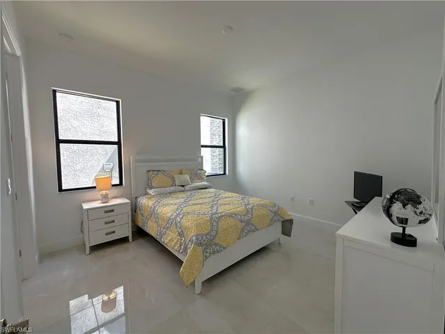 a spacious bedroom with a bed and chair in it