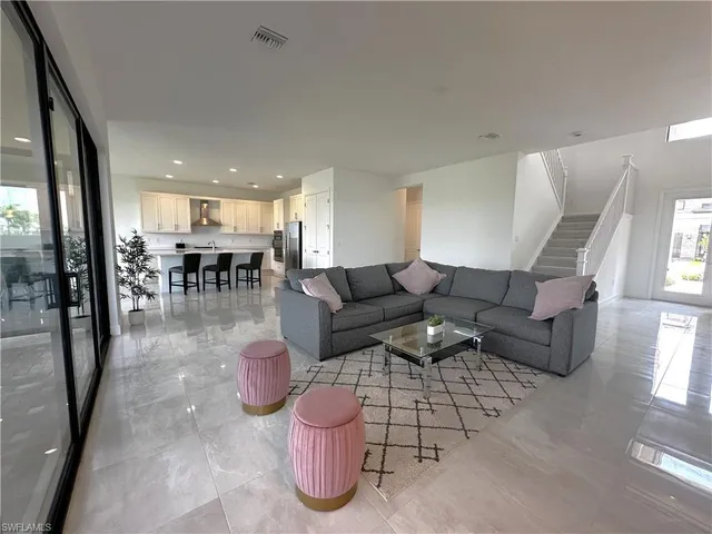a living room with furniture and a kitchen appliance view