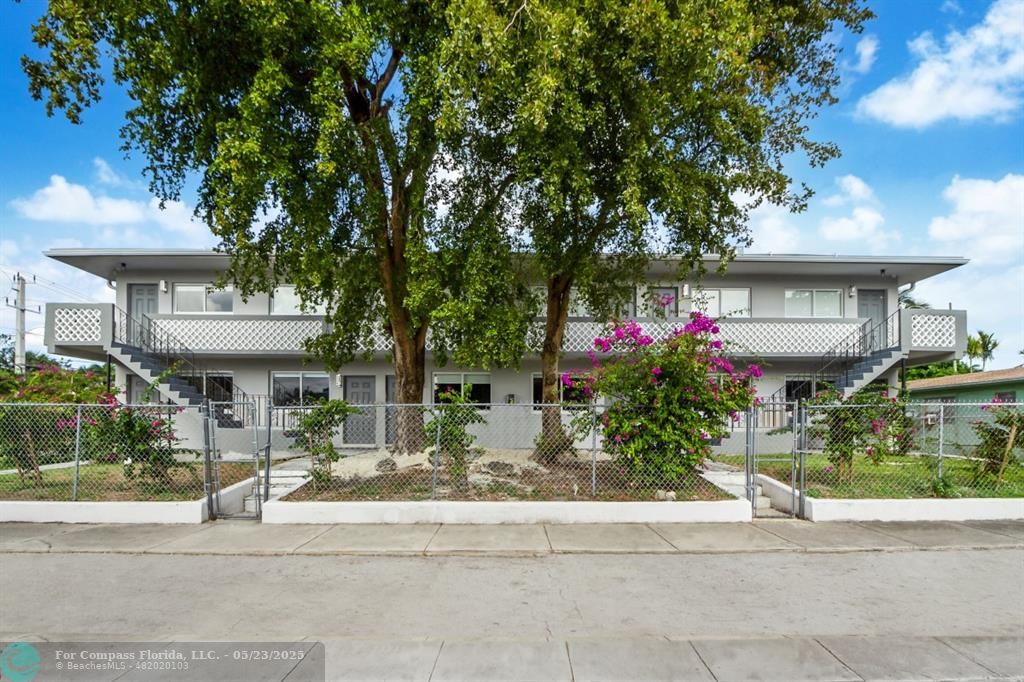 1001 Northeast 80th Street, Unit 4 Miami, FL 33138 - Photo 1 of 27 a front view of a house with a yard and a fountain