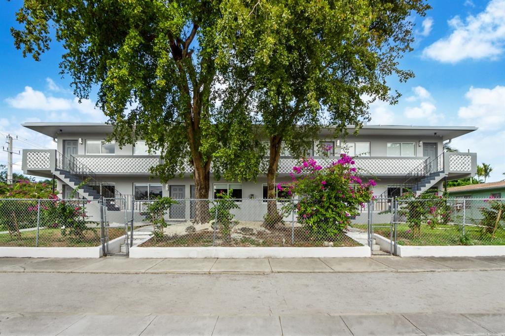 a front view of a house with a yard and a fountain