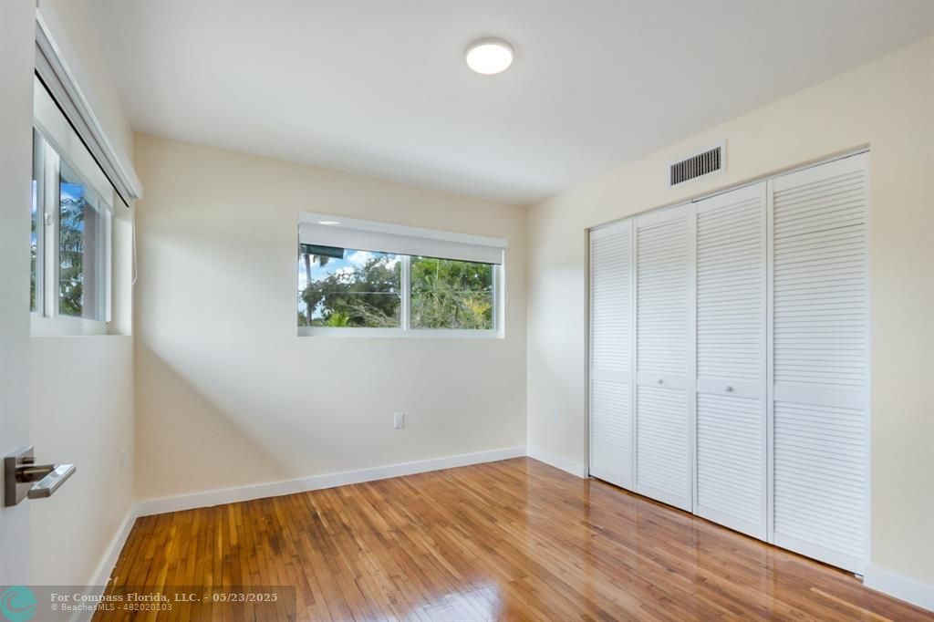 1001 Northeast 80th Street, Unit 4 Miami, FL 33138 - Photo 16 of 27 an empty room with wooden floor and windows
