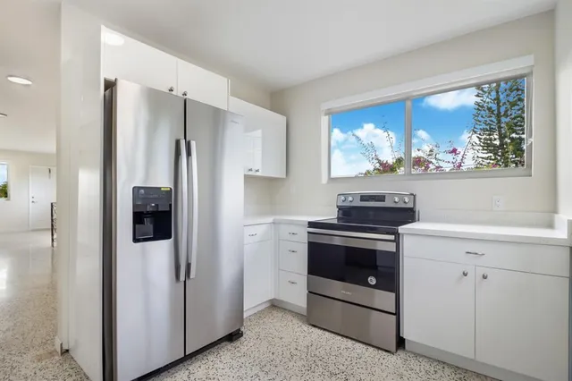 a kitchen with stainless steel appliances granite countertop a refrigerator stove and sink