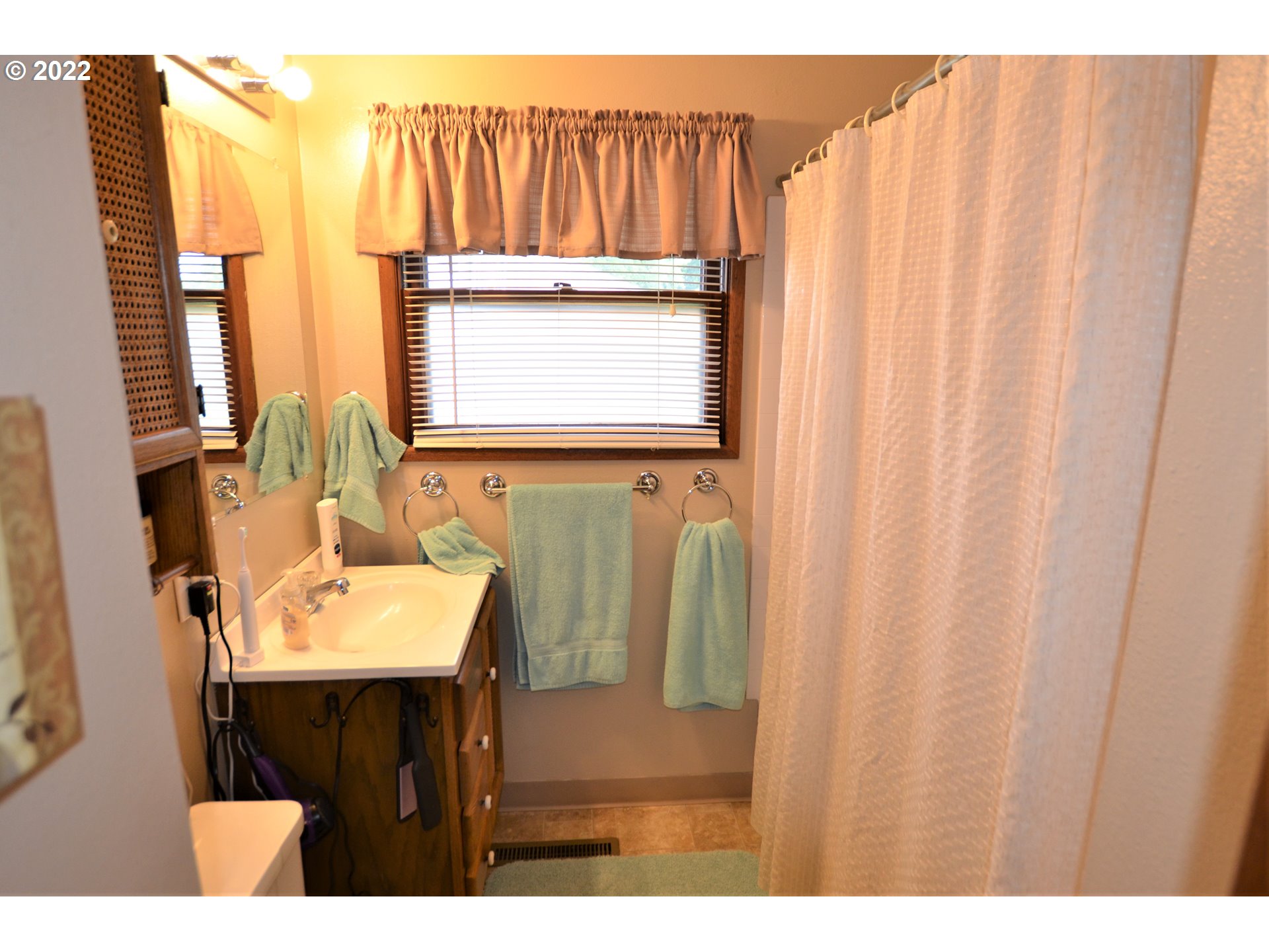 1585 Southwest 40th Street Pendleton, OR 97801 - Photo 8 of 20 a bathroom with a sink a mirror and a shower curtain