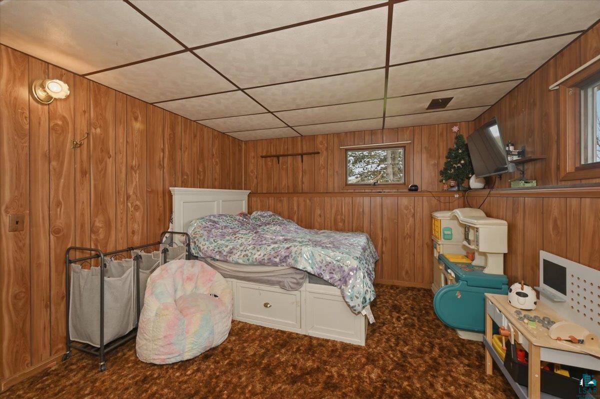 5190 County Road M Gordon, WI 54838 - Photo 12 of 31 Room featuring wood-paneled walls, a drop ceiling, and brown textured carpet