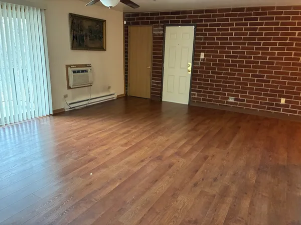 a view of a livingroom with wooden floor and a flat screen tv