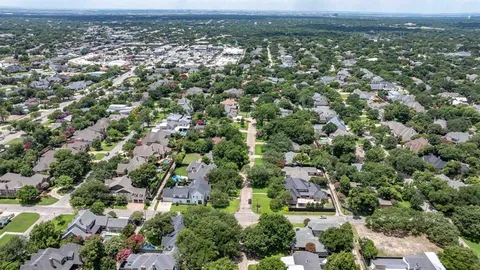 an aerial view of residential houses with outdoor space and trees